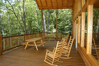 spacious deck with picnic table and rocking chairs